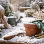 Zaśnieżony ogród zimowy z krzewami i rabatami pokrytymi śniegiem, przedstawiający rośliny zabezpieczone przed mrozem w naturalnym, spokojnym krajobrazie